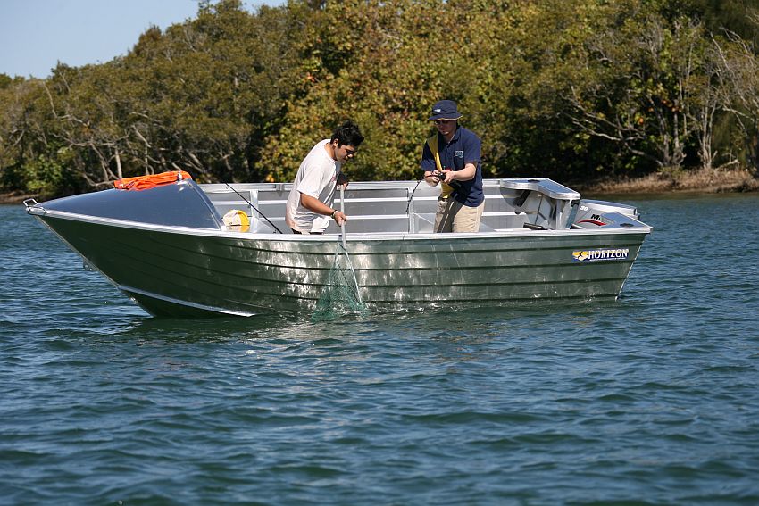 a couple of people on a small boat in the water 